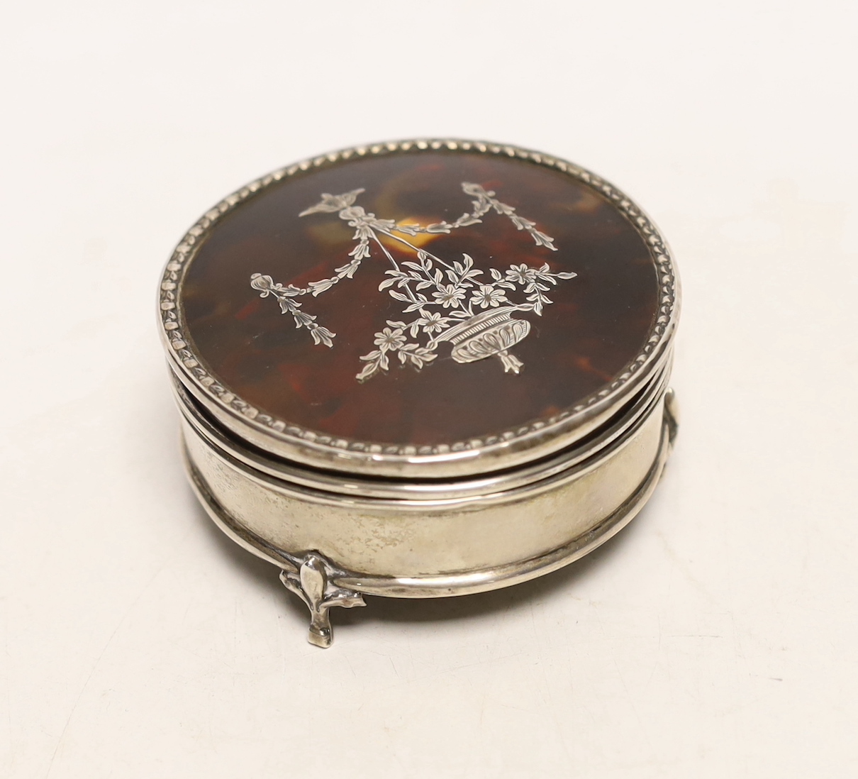 A George V silver and tortoiseshell pique circular trinket box, Goldsmiths & Silversmiths Co Ltd, London, 1913, diameter 71mm.